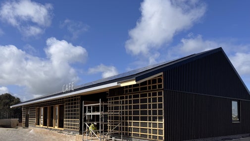New café building under construction at Sandilands Nature Reserve, with timber framing, black cladding and scaffolding under a blue sky.